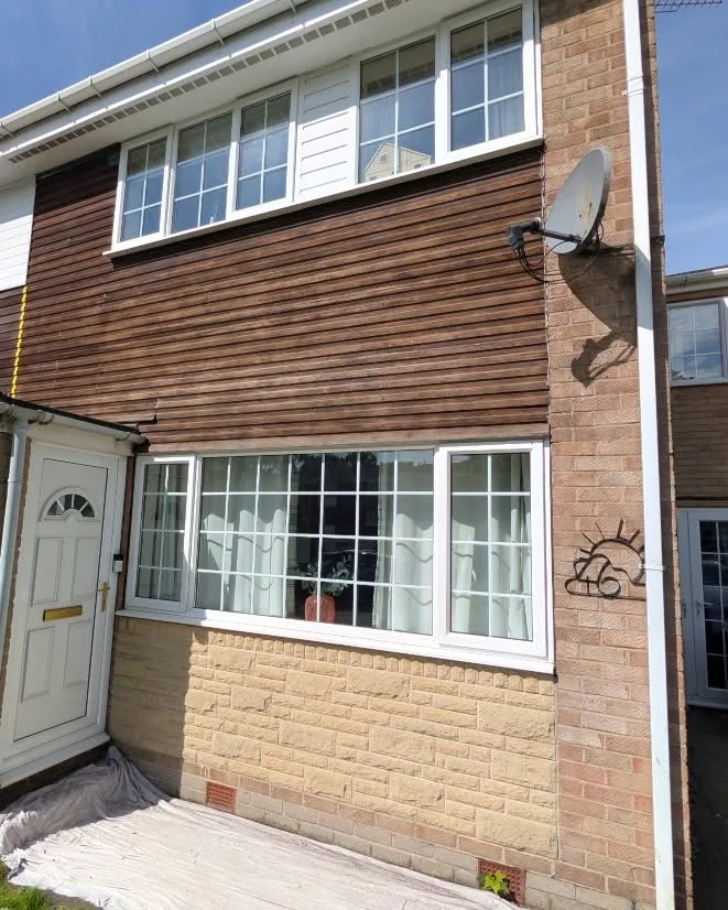 House frontage before repainting, with weathered brown timber cladding