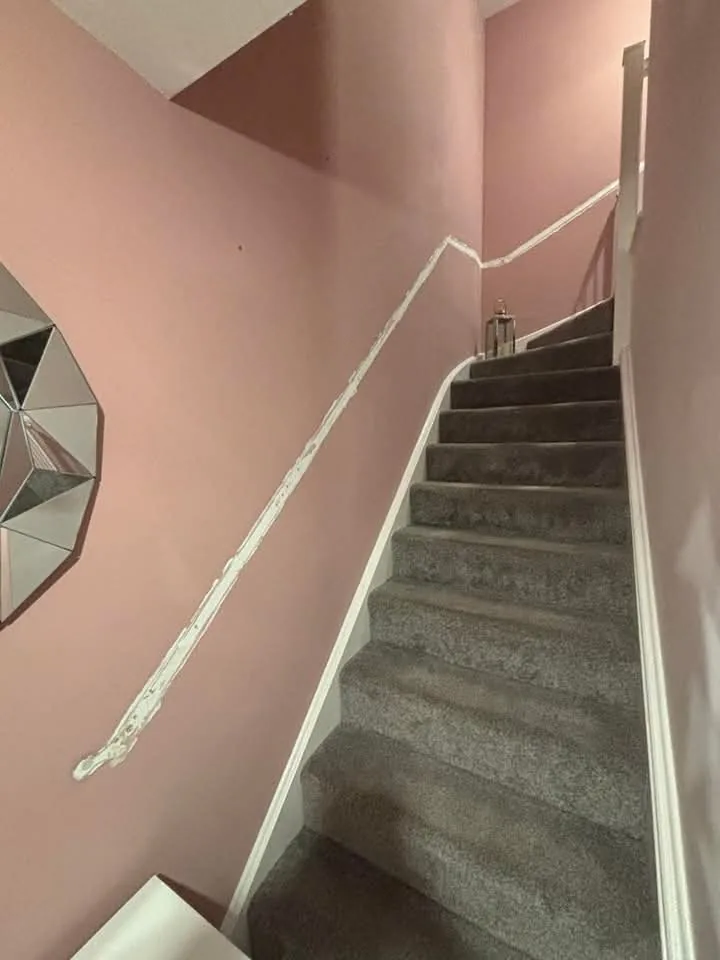Staircase before redecoration, with muted pink walls and a removed handrail