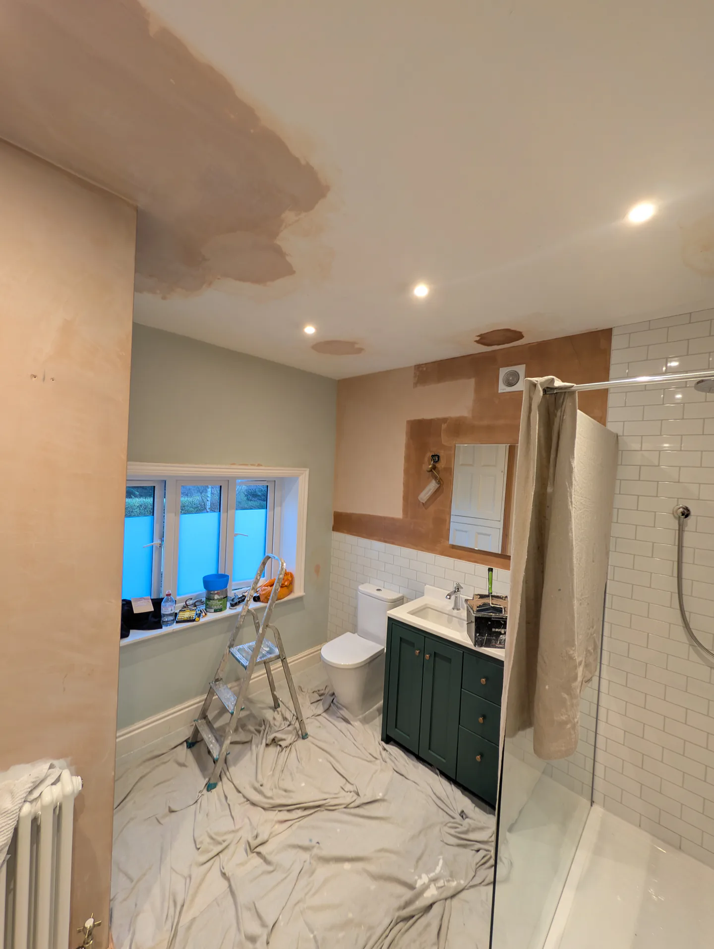 Bathroom during redecoration, with prepared walls and protective floor coverings